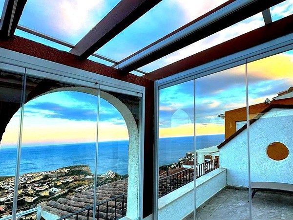 Cerramiento con cortina de cristal y techo fijo
